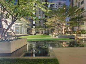a park with a pond in front of a building at Diamond in Bangkok