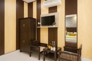 a hotel room with a television and a bedroom at Oslo Green By Around Stays, Tapovan, Rishikesh in Rishīkesh