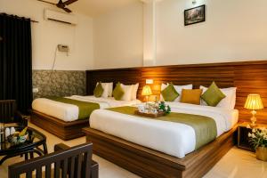 a hotel room with two beds and a table at Oslo Green By Around Stays, Tapovan, Rishikesh in Rishīkesh
