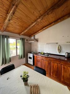 a kitchen with a table with chairs and a stove at DEPARTAMENTOS FORTIN in Trevelín