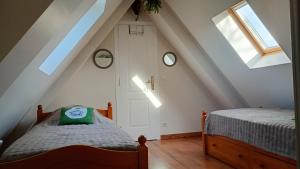 a attic bedroom with a bed and a window at Le Pressoir in Cresseveuille