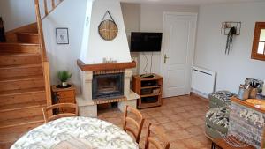 a living room with a fireplace and a television at Le Pressoir in Cresseveuille