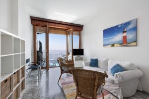 a living room with a white couch and a lighthouse at Appartamento stupenda vista mare in Bergeggi