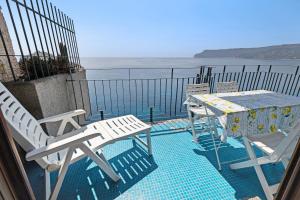 two chairs and a table on a balcony with the ocean at Appartamento stupenda vista mare in Bergeggi