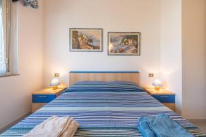 a bedroom with a bed with two lamps and two pictures on the wall at L'acquario in Villasimius