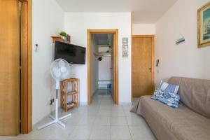 a living room with a couch and a flat screen tv at L'acquario in Villasimius