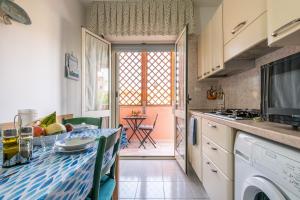 a kitchen with a table and a dining room at L'acquario in Villasimius