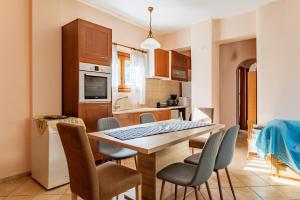 a kitchen and dining room with a table and chairs at Moraki Apartment 2 Andros in Korthi