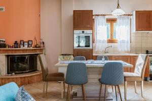 a kitchen with a table and chairs and a fireplace at Moraki Apartment 2 Andros in Korthi +19 photos