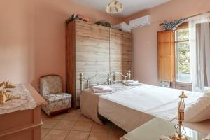 a bedroom with a large bed and a chair at Moraki Apartment 2 Andros in Korthi