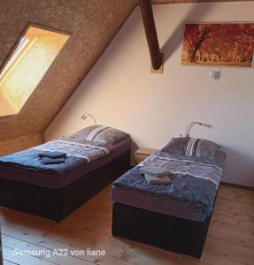 two beds in a attic room with a window at Haus beim Schloß in Woldegk