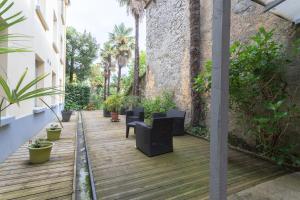 a wooden deck with chairs and plants on a building at T3 ensoleillé le Vignemale in Lourdes