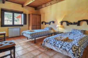 a bedroom with two beds and a window at El Mirador de Babia in Ríolago