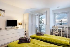 a bedroom with a yellow bed and a television at Schwarzwaldblick D App 8 mit Pool in Schönwald