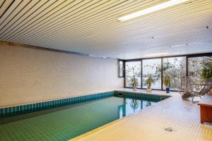 a swimming pool in a building with a pool at Schwarzwaldblick D App 8 mit Pool in Schönwald