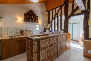 a kitchen with wooden cabinets and a counter with a sink at Gite à la campagne in Ginestet +17 photos