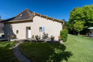a white brick house with potted plants in a yard at Gite à la campagne in Ginestet