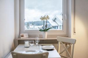 a table and chairs in a room with a window at Schwarzwaldblick D App 8 mit Pool in Schönwald