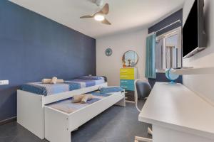 a bedroom with two beds and a tv at Casa Betta in Costa Calma