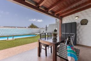 a patio with a table and chairs and a pool at Casa Betta in Costa Calma