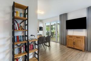 a living room with a tv and bookshelves at Ferienhaus Diemelblick in Heringhausen