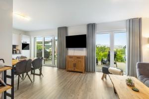 a living room with a television and a dining room at Ferienhaus Diemelblick in Heringhausen