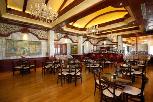 a restaurant with tables and chairs in a room at Hotel VD Roleks in Vlorë
