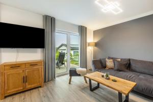 a living room with a couch and a flat screen tv at Ferienhaus Diemelblick in Heringhausen