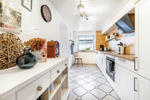 a kitchen with white cabinets and a clock on the wall at Kempers Auszeit in Plettenberg +26 photos