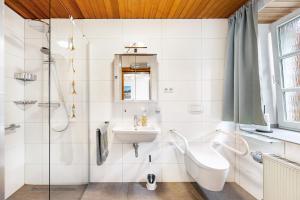 a white bathroom with a sink and a shower at Kempers Auszeit in Plettenberg