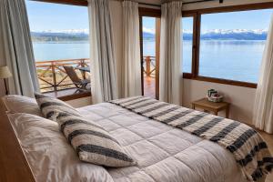 a bedroom with a bed with a view of the water at Blue Aparts Dina Huapi Bariloche in Dina Huapi