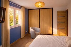 a bedroom with a bed and a chair and a window at Entre Nature et Océan in Commequiers +9 photos