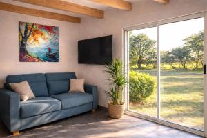 a living room with a blue couch and a tv at Entre Nature et Océan in Commequiers
