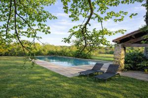 a pool with two chairs in a yard at Entre Nature et Océan in Commequiers
