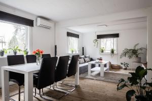 a dining room with a white table and black chairs at the Little Oasis In Gothenburg in Gothenburg
