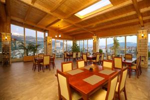 a dining room with tables and chairs and windows at Hotel VD Roleks in Vlorë