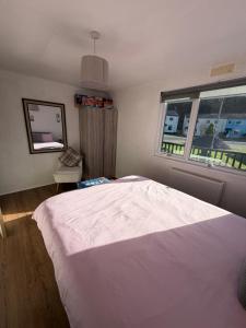 a bedroom with a large white bed and a window at Edwards cabin in Caeathro
