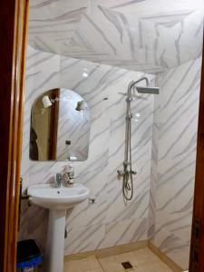 a white bathroom with a sink and a mirror at Dar dyafa in Meknès