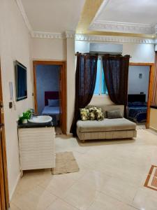 a bedroom with a couch and a sink in a room at Dar dyafa in Meknès