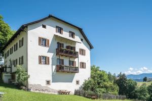 a white building with balconies on a hill at Sallrain Hof Apartment 2 in Collalbo