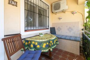 a balcony with a table and a bench and a window at Heads 2 Holiday Homes Apartment in Villamartin