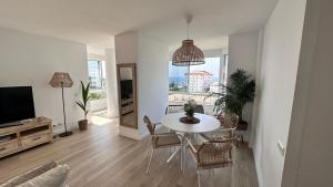 a living room with a table and chairs and a television at Casa Lydia in Torrox Costa