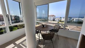 a balcony with a table and chairs and windows at Casa Lydia in Torrox Costa