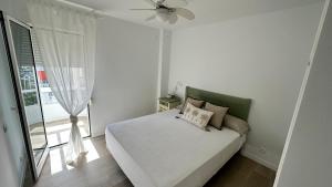 a white bedroom with a bed and a window at Casa Lydia in Torrox Costa +23 photos
