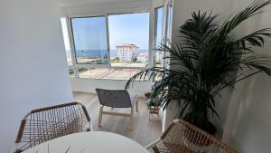 a living room with a potted plant and a large window at Casa Lydia in Torrox Costa