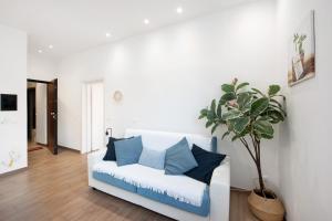 a white couch with blue pillows in a living room at Rosa dei Venti - Centro Storico in Varazze