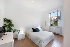 a white bedroom with a white bed and a window at Rosa dei Venti - Centro Storico in Varazze