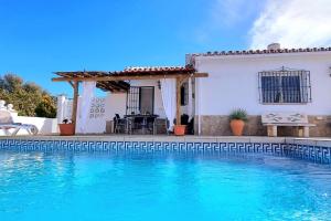 a villa with a swimming pool in front of a house at Casa La Paz in Torrox