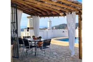 a patio with a table and chairs and a pool at Casa La Paz in Torrox