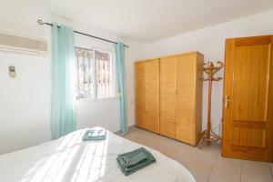 a bedroom with a bed and a wooden cabinet at Casa La Paz in Torrox